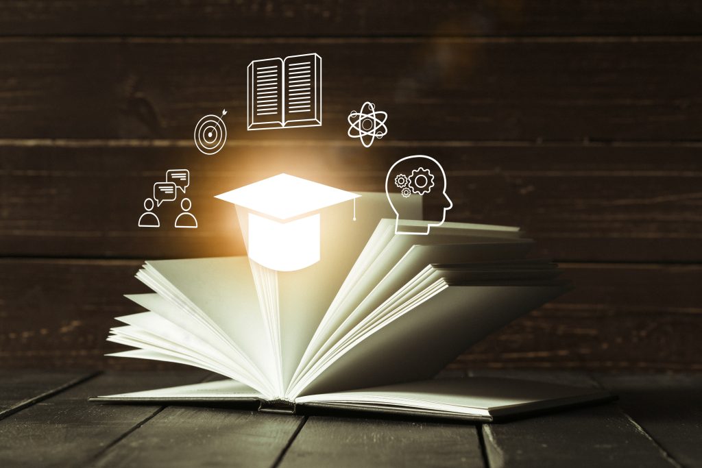 E learning and education concepts with open book and icons in a classroom setting